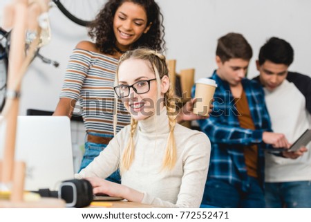 girl with braces sitting with laptop and looking at camera