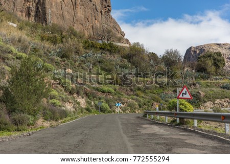 Street with double curve road sign in Gran Canaria