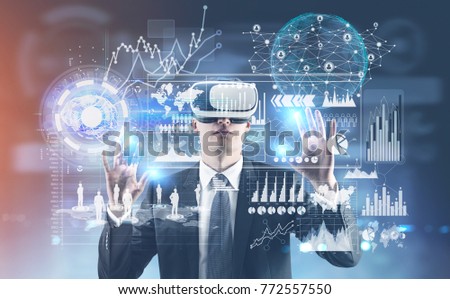 Young businessman wearing a suit and VR glasses and interacting with what he sees. HUD and infographics. Toned image double exposure Elements of this image furnished by NASA