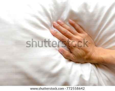 Top view of right hand woman pressure white pillow or bedding. Soft pillow good sleep, good health. Flat Lay. Copy space for any text design. Healthcare concept. Royalty-Free Stock Photo #772558642