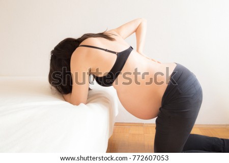 Pregnant woman having contractions in labour pain  Royalty-Free Stock Photo #772607053