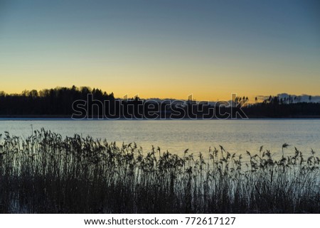 Beautiful nature and landscape photo of sunset at winter in Sweden Scandinavia. Nice colorful outdoors image of dusk evening. Calm, peaceful and joyful picture.