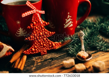 Picture of beautiful Christmas table setting, shining white plate with red cup for coffee decorated holiday dinner, branch of berry and santa claus star on festive dishware, New Year party, xmas eve