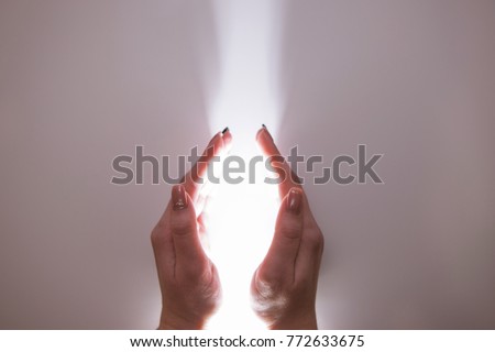 Hands reaching out to holy light. Miracle faith in God and religion concept