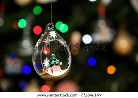 Small Christmas tree inside glass ornament hanging on Christmas tree