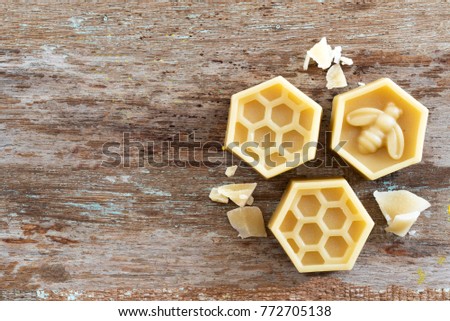 natural yellow beeswax on wooden background. Royalty-Free Stock Photo #772705138