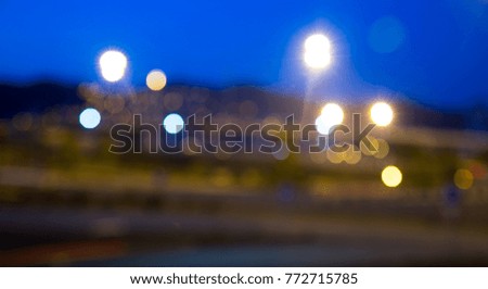 Blurred view of city highway in dusk with trace of red automobile headlight beams