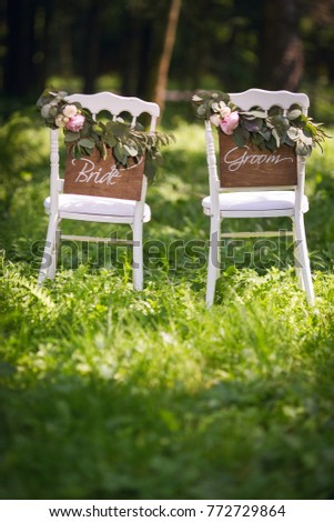 Bride and groom. Wedding bride and groom Signs on chairs standing in the woods. 
