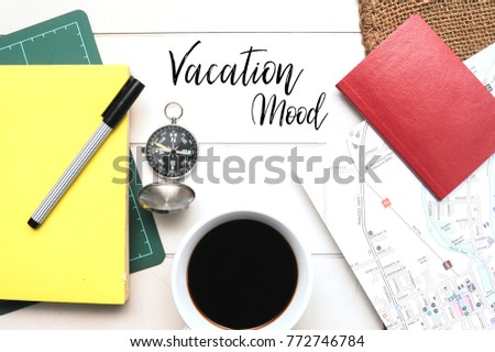 Travel Concept.Book,Passport,pen,Coffee,navigation compass and a map on the white table with vintage canvas sack written with words VACATION MOOD.