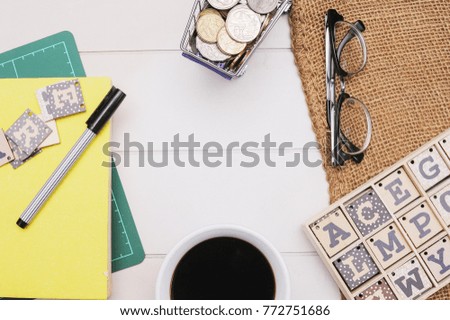 Business Concept Flay Lay.Book,pen,spectacle,alphabet blocks and coins on the rustic white table with vintage canvas sack.Business flat lay with copy space.