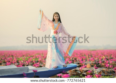 picture of beautiful woman with lotus flower,young woman relaxing with beautiful lotus flower field at the red lotus sea, Bua Daeng, Udon Thani, Thailand
