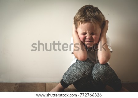 Boy shouts covered his ears with his hands. Stressed child. Domestic Family violence and aggression concept violence. concept for bullying, depression stress or frustration. Royalty-Free Stock Photo #772766326
