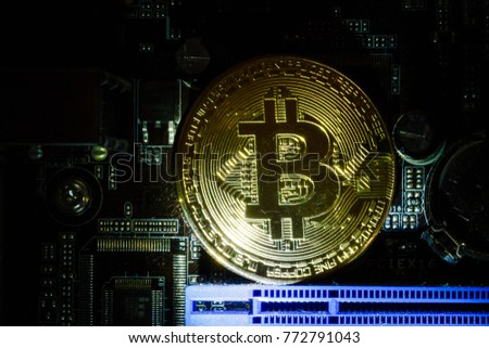 Golden bitcoin cryptocurrency on computer circuit board 