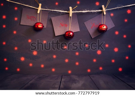 Happy new year on paper with a clothespin, hanging on a rope on a dark wooden background. Greeting card with a happy new year. Holidays. Gifts.