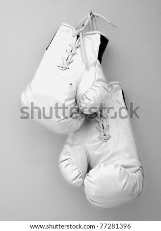 White boxe gloves pending from a nail on a wall Royalty-Free Stock Photo #77281396