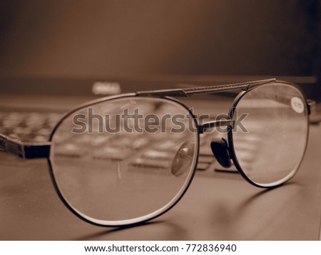 Glasses on the keyboard of laptop after working monotone