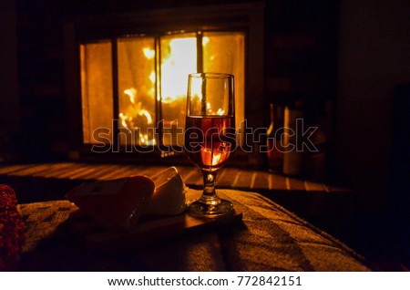 Glass of Wine and Cheese Sitting in Front of Roaring Fire in Fireplace; High Contrast
