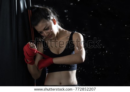 A young boxer is using a bandage at her own hands to prepare for rehearsals. In modern day boxing, women are more likely to learn and practice martial arts, and will also help with physical health.