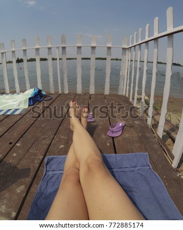 women's legs on the beach in front of the water