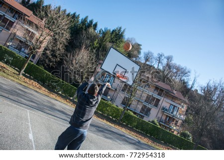 Guy playing alone on basketball playground