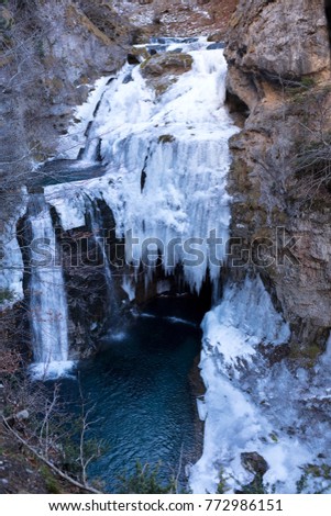 waterfall of frozen water with a strem falling. Ordesa, natural park Spain