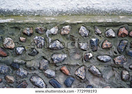 Wall with various cemented stones in it