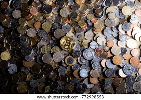 Golden Bitcoin - virtual crypto currency, financial concept, in a pile of other coins of different countries. High resolution close up 
