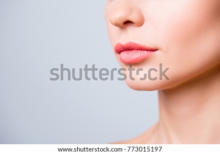 Cropped close up photo of beautiful woman's lips with shape correction, isolated on grey background, copyspace
