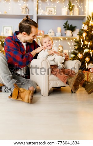 Festive photo of boy on chair and happy dad
