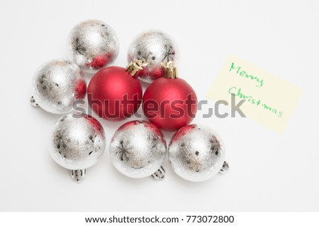 Merry christmas writen on yellow sheet and christmas ball on white background