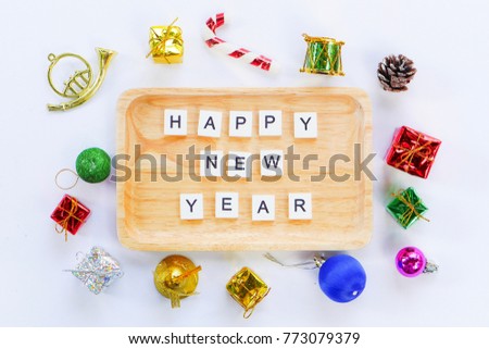 Happy New Year wooden wording on the vintage wooden plate among colorful Christmas decorations with white background. The picture concepts are celebrated, gift card, presents.