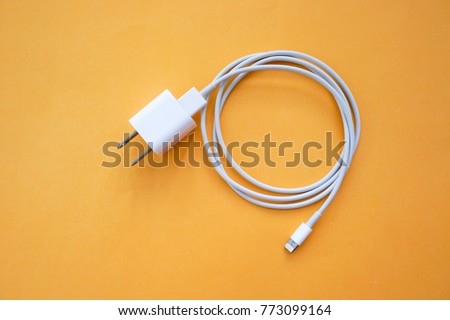 Mobile Phone Charger on Orange Background Top View Royalty-Free Stock Photo #773099164