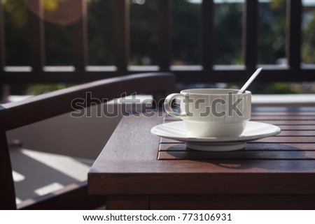 Cup of gourmet coffee. Morning cup of black hot coffee placed on wooden table on the balcony in tropical Thailand.