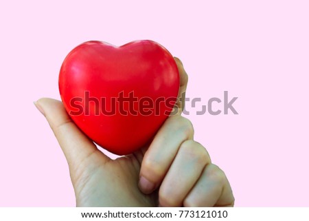 closeup of Red heart in the hand isolated on pink background.
Valentine day or love concept.