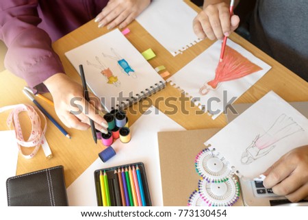 Young woman professional Fashion designer working and drawing sketches on the table , Designer Stylish Concept.
