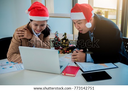 Group of young business people are sitting in Santa hats in last working day. young creative people are celebrating holiday in modern office. Merry Christmas and Happy New Year 2018