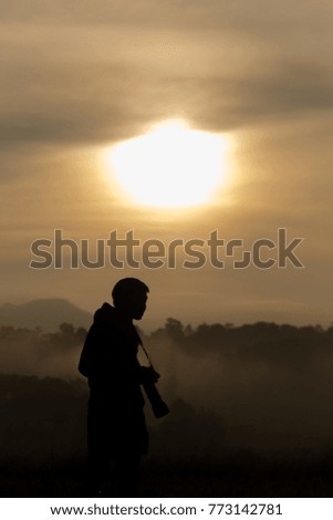 silhouette man photographer with sunset and sunlight fog