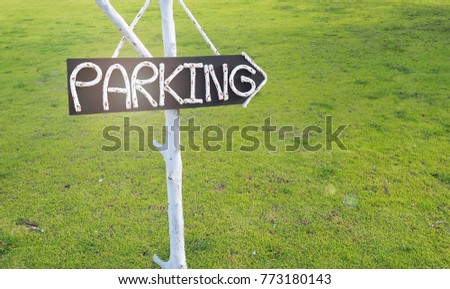 Parking sign in the retro style with green grass background.