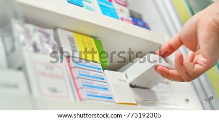 Closeup pharmacist hand holding medicine box in pharmacy drugstore. Royalty-Free Stock Photo #773192305