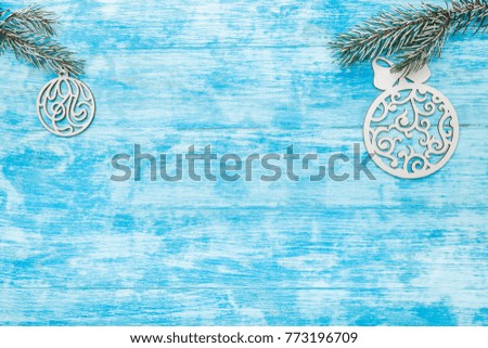 Fir branches, with wooden handmade evergreen toy globes, view from above, top, on light blue, wood background, Xmas greeting card, with space for text wish