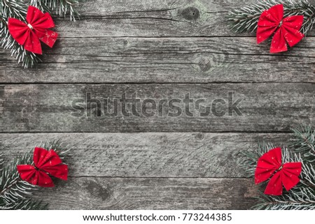 Four fir branches with red bows, and xmas handmade toys on wooden gray background, with space for text, Christmas greeting card