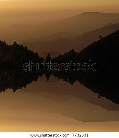 mountain layers sunset, with lake water reflection