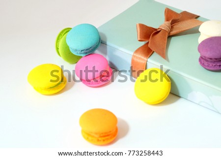 Sweet pastel macaroons cake in a gift box with brown ribbon on white table,  colorful macaroons sweet and romantic concept