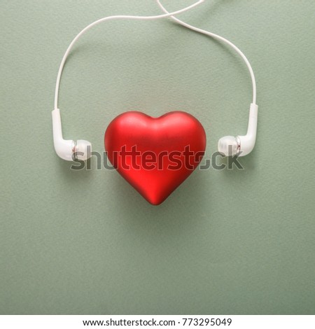 The photo shows headphones listening to the enamored red heart. This is the concept of the holiday of all lovers of St. Valentine's Day.