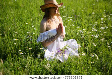 Summer yoga meditating woman in green grass field