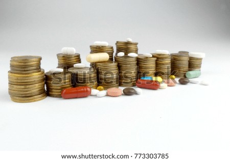 Pills and coins isolated on white background