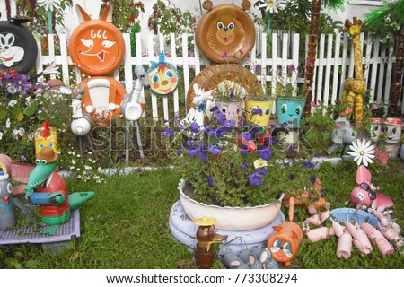 Flower garden near the farmhouse. Figurines of cartoon characters made from old plastic bottles delight adults and children.