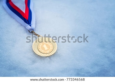 Gold medal, first place, trophy, blue snow background