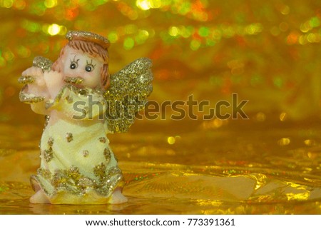 Toy Christmas angel on a gold background