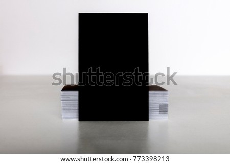 A mockup for a black business card, side view on light textures, with a place for text